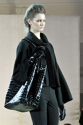pokaz mody: eva minge, modelka w czarnej sukience ora czarną torbą